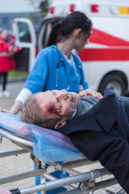 kadın doktor yaralı olgun adam ambulans sedye üzerinde hareket