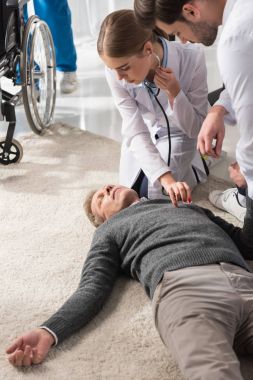 kadın doktor kontrol bilinçsiz orta yaşlı adam Çarpıntım stetoskop ile  