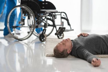 unconscious middle aged man lying on a floor in hospital clipart