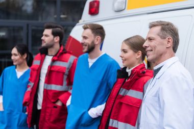 Ambulans doktorlar çalışma ekibi gülümseyen ve arabanın önünde duran