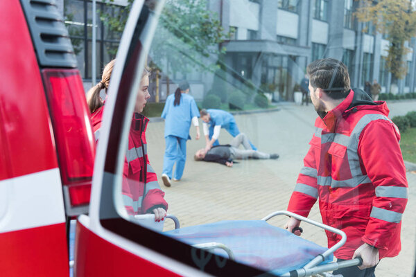 view through window of paramedics helping injured man