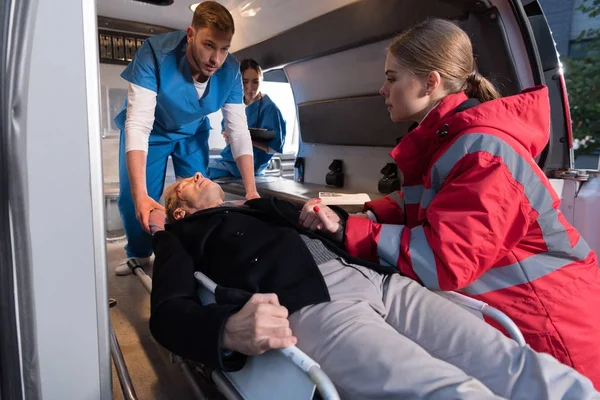 Paramedics Moving Wounded Mature Man Ambulance Stretcher — Stock Photo, Image