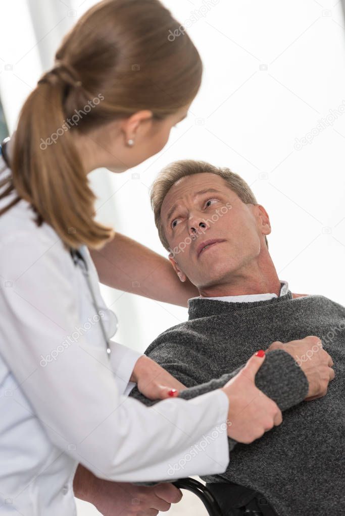 cropped image of doctors helping man with disability