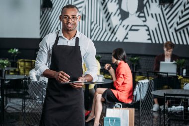 yakışıklı genç garson önlük ayakta Café