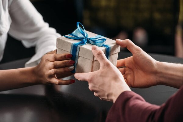 обрезанный снимок мужчины, дарящего подарок девушке на годовщину
