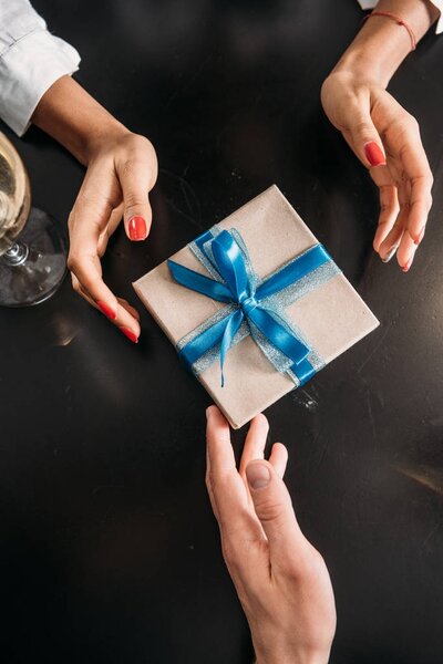 cropped shot of boyfriend giving present to girlfriend