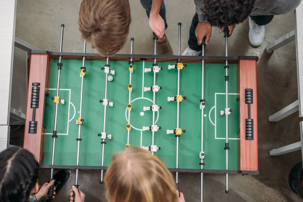 近代的なオフィス テーブル サッカーで遊んでトリミングの多文化の人々 のトップ ビュー — ストック写真