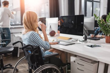 incapacitated person in wheelchair working at modern office clipart