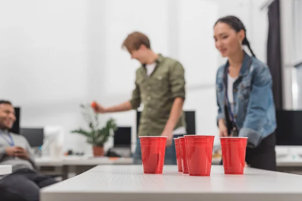 下班后在现代办公室玩啤酒乒乓的年轻工人 — 图库照片