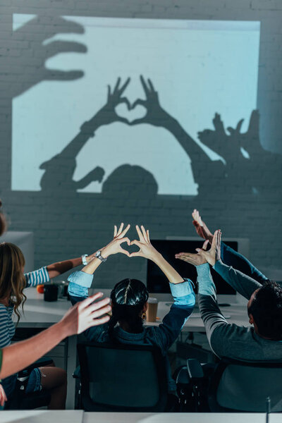 young people playing with shadows after work in modern office