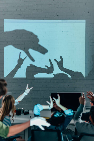 young people playing with shadows after work in modern office