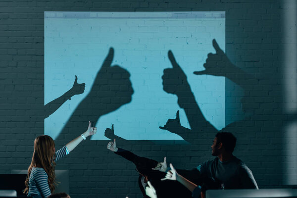 young attractive people playing with shadows after work in modern office