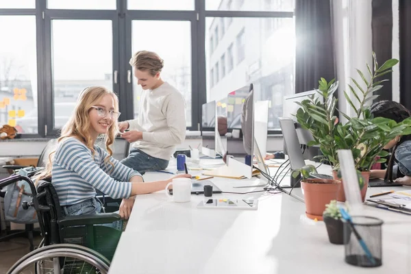 モダンなオフィスで働いている車椅子で幸せな心身障害のある人 — ストック写真