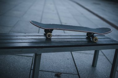 old skateboard standing on bench outdoors clipart