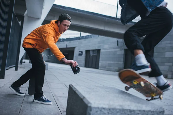 Skateboarder Tomando Una Foto Compañero Haciendo Truco Aire Libre — Foto de Stock