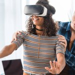 Caucasian boy holding african american girl watching something with virtual reality headset