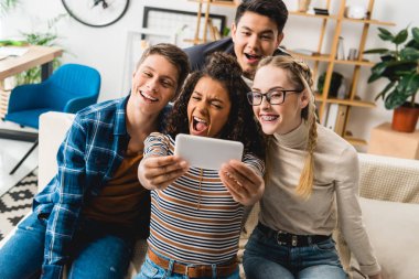 selfie smartphone ile evde alarak mutlu çok ırklı gençler