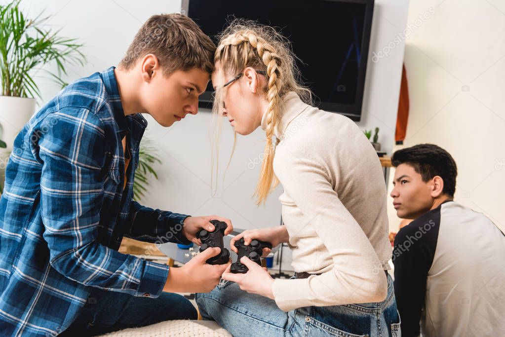 boy and girl aggressively touching with foreheads while playing video game