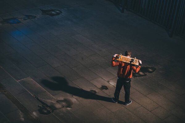 high angle view of skateboarder standing with board on shoulders