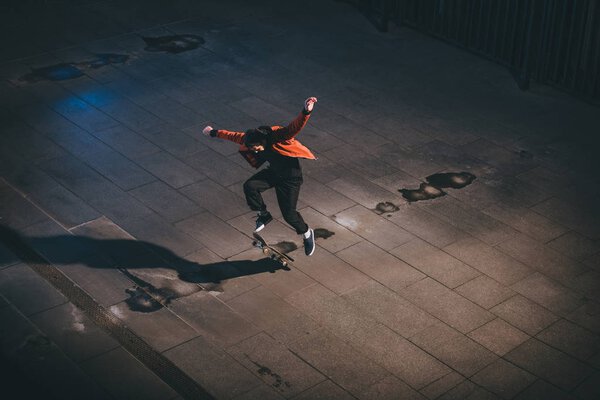 высокий угол обзора скейтбордиста, выполняющего прыжковый трюк
