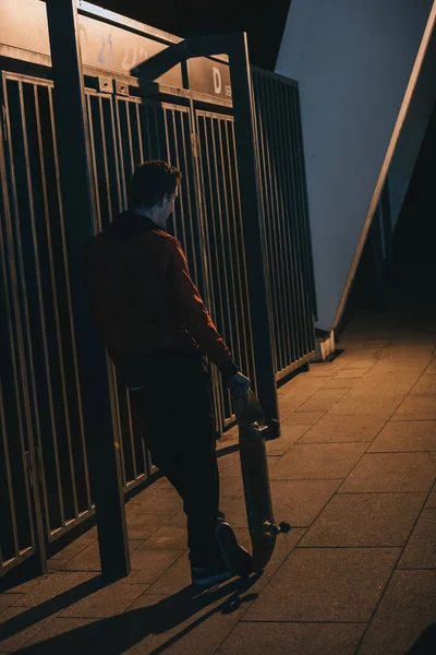 Mężczyzna Stojący Deskorolka Zewnątrz Późnych Nocy — Darmowe zdjęcie stockowe