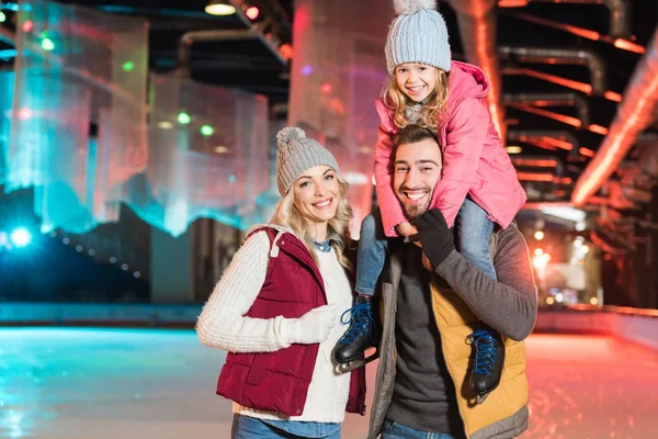 スケート リンクに一緒に時間を過ごしながらカメラに笑顔幸せな若い家族 — ストック写真