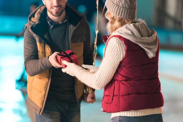 Cropped Shot Young Man Presenting Gift Box Girlfriend Rink — Free Stock Photo