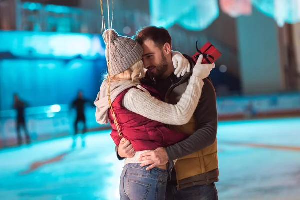 Happy Young Couple Hugging Rink While Girl Holding Gift Box — Stock Photo, Image