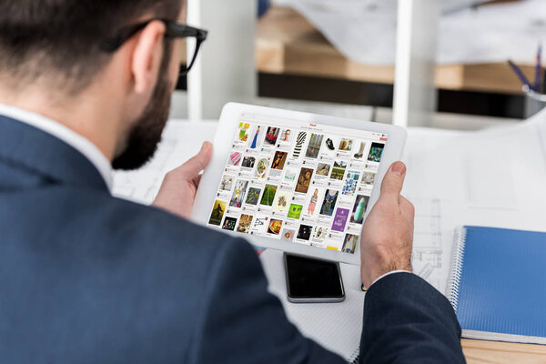 businessman holding tablet with loaded pinterest page