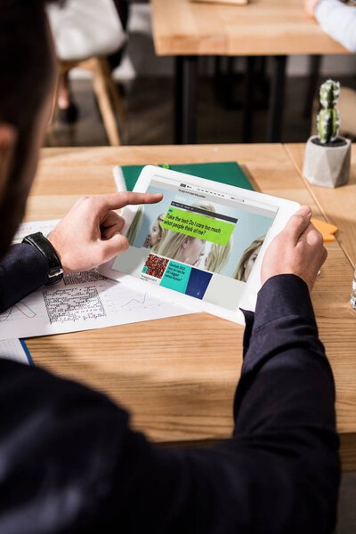 cropped image of businessman holding tablet with loaded bbc science page