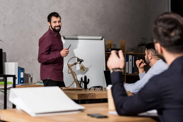 Sonriente Hombre Negocios Pie Con Pluma Cerca Del Rotafolio — Foto de Stock