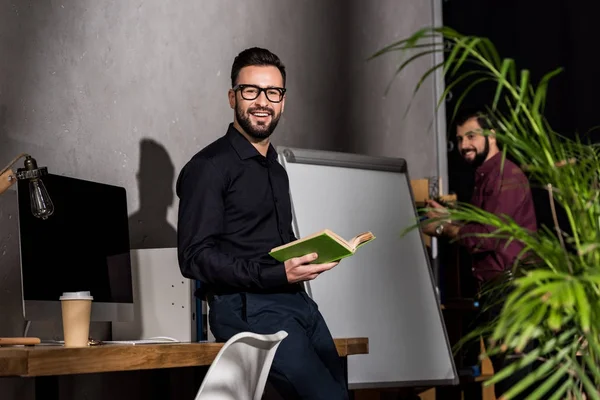 Χαμογελώντας Επιχειρηματίας Στέκεται Βιβλίο Στο Γραφείο Και Βλέπουν Φωτογραφικών Μηχανών — Φωτογραφία Αρχείου