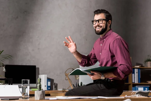 Homem Negócios Sorridente Acenando Mão Sentado Mesa Trabalho — Fotografia de Stock