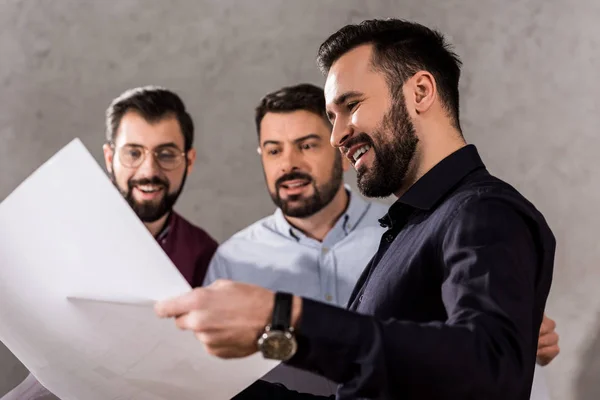 Lächelnde Architekten Bei Der Betrachtung Von Bauplänen Arbeitsplatz — Stockfoto