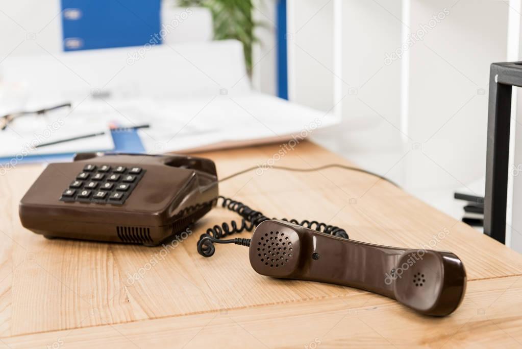 handset of black stationary telephone on table