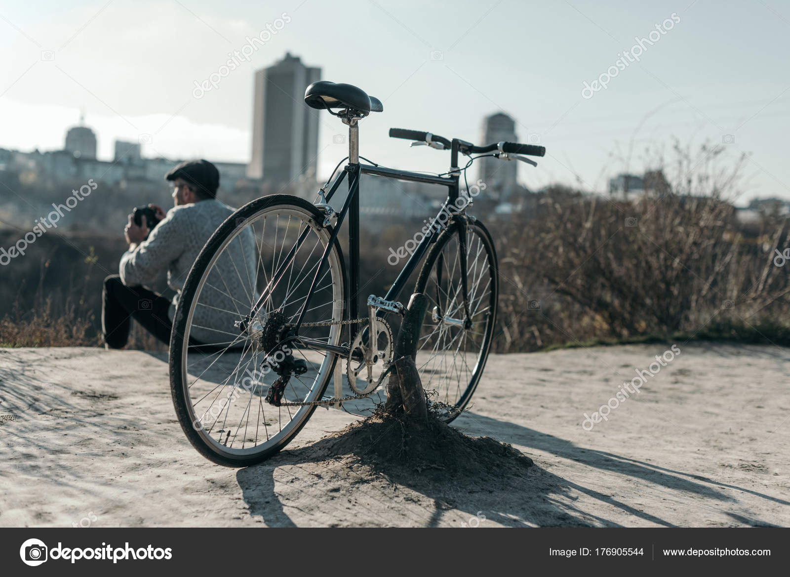Hombre Adulto Con Bicicleta Sentado Camino Rural Mirando Ciudad: fotografía  de stock © ArturVerkhovetskiy #176905544
