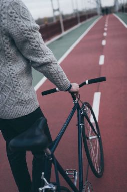 cropped shot of man with vintage bicycle on pedestrian bridge clipart