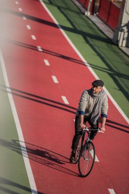 yakışıklı yetişkin adam binicilik bisiklet taze boyalı bisiklet yolu üzerinde yüksek açılı görünüş