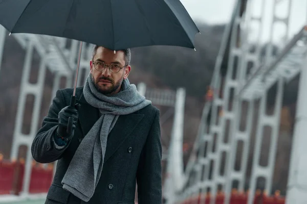 Schöner Mann Mittleren Alters Mit Regenschirm Der Über Eine Brücke — Stockfoto