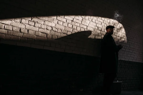 Silhouette Adult Man Smoking Front Brick Wall — Free Stock Photo