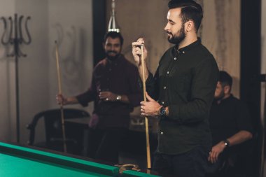 yakışıklı adam sürtünme cue tebeşir ile bar arkadaş grubu