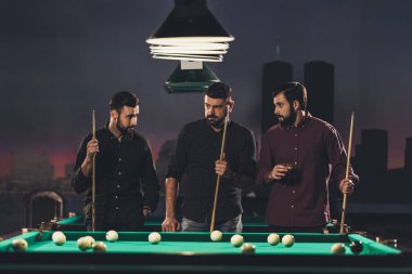 Bilardo masası içkiyle yanında duran başarılı yakışıklı erkeklerle bar