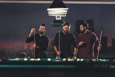 Bilardo masası içkiyle yanında duran başarılı yakışıklı erkeklerle bar  