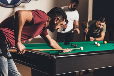company of handsome men playing in pool  clipart