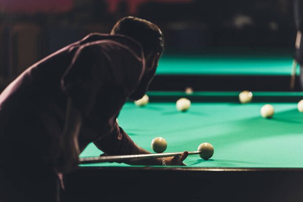 back view of man playing in russian pool at bar 