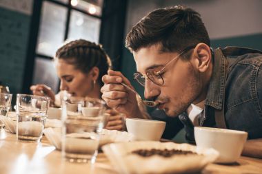 Kahve dükkanında çalışanlar kahve içme etkinliği sırasında kahve kalitesini kontrol ediyorlar.