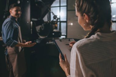 seçici odak kadın kontrol meslektaşlarının iş kahve kavurma işlemi sırasında