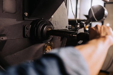 partial view of coffee roaster working on roasting machine clipart