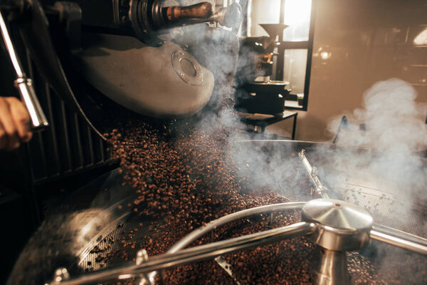close up view of coffee beans roasting in machine