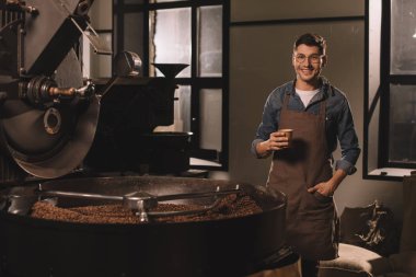 smiling coffee roster with cup of coffee having break during work clipart